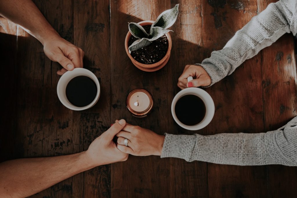 couples-therapy-couple-holding-hands-drinking-coffee