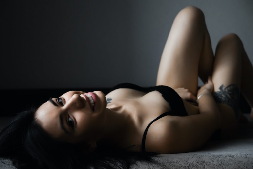 how-to-perform-cunnilingus-woman-smiling-lying-on-bed-in-black-lingerie